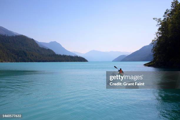 a single kayaker in ocean. - seniors canoeing stock pictures, royalty-free photos & images