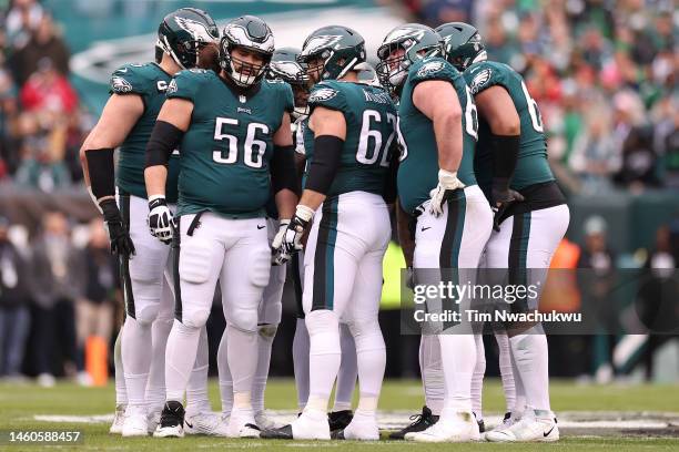 Isaac Seumalo, Jason Kelce and Landon Dickerson of the Philadelphia Eagles huddle with their teammates against the San Francisco 49ers during the...