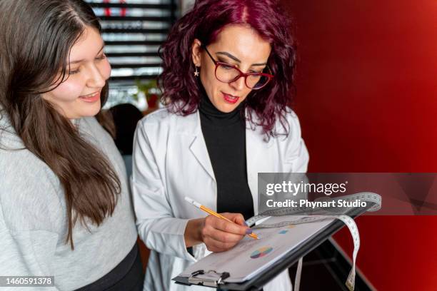 nutricionista asesora a paciente adolescente en el interior de la oficina - chubby girls photos fotografías e imágenes de stock