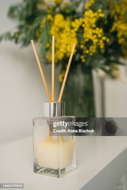 air freshener for home standing on the table. fragrance diffuser. yellow mimosa flowers in vase. - air freshener stockfoto's en -beelden