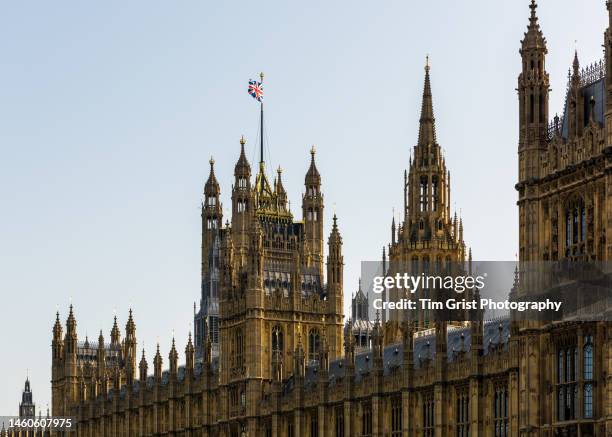 union jack flag flying over the houses of parliament, london. - house of commons stock pictures, royalty-free photos & images