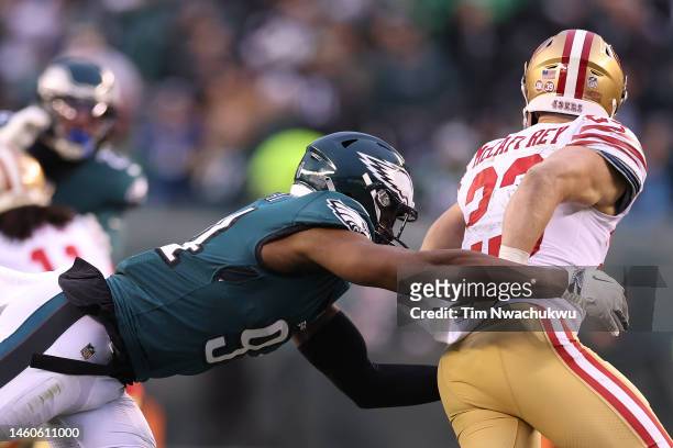 Christian McCaffrey of the San Francisco 49ers carries the ball against Josh Sweat of the Philadelphia Eagles during the third quarter in the NFC...