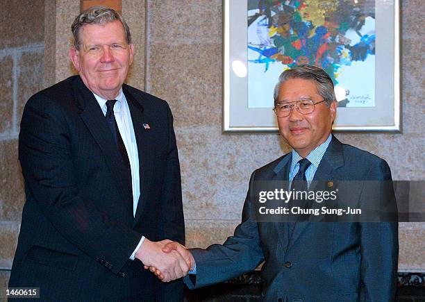Assistant Secretary of State James Kelly shakes hands with South Korean Foreign Minister Choi Sung-hong at Choi's home October 5, 2002 in Seoul,...