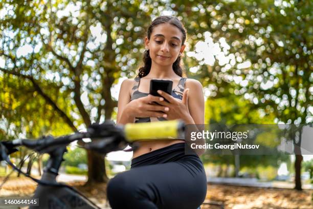 teenager mit einem fahrrad im park. - tiny mexican girl stock-fotos und bilder