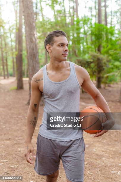 man in wooded park arriving at basketball court - segurar 個照片及圖片檔