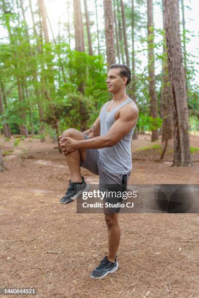 man stretching in wooded park - etnia caucasiana stockfoto's en -beelden