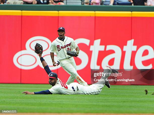 Jason Heyward of the Atlanta Braves makes a diving catch as Michael Bourn reacts during the game against the Toronto Blue Jays at Turner Field on Jue...