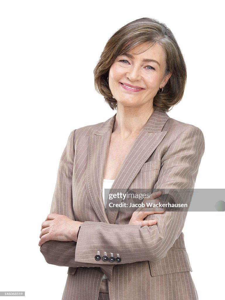 Close-up of businesswoman smiling with arms crossed against white background