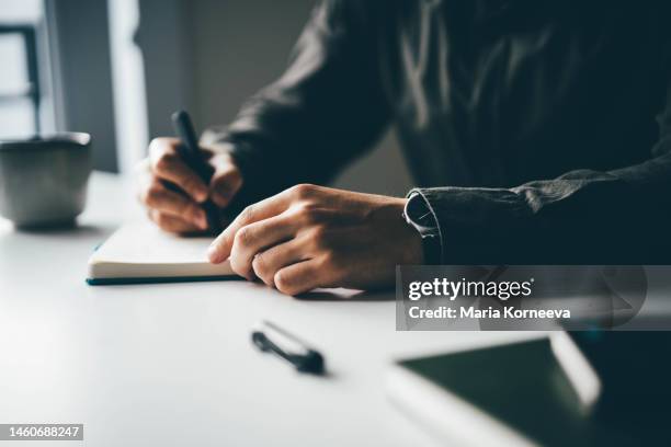 close-up businessman writing and drawing in notebook. - man holding paper stock pictures, royalty-free photos & images