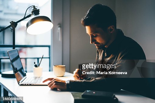 Young businessman working on laptop at home.
