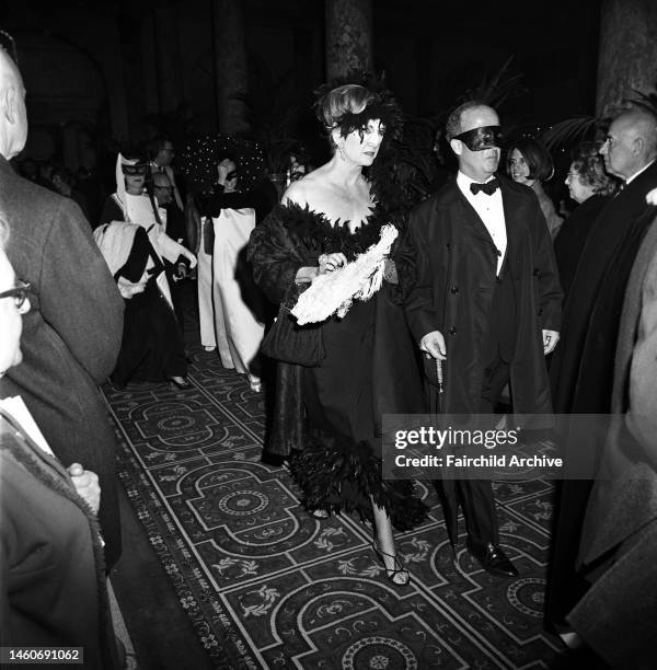 Couple in masks arriving at Truman Capote's Black and White Ball in the Grand Ballroom at the Plaza Hotel in New York City