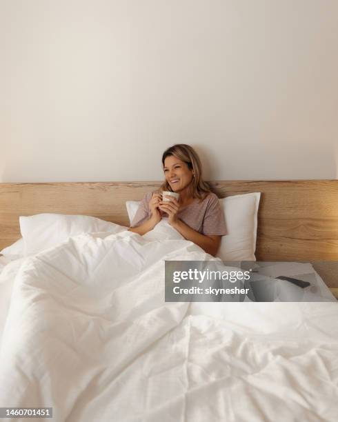 relaxed woman enjoying in morning coffee in a bed. - bedclothes stock pictures, royalty-free photos & images