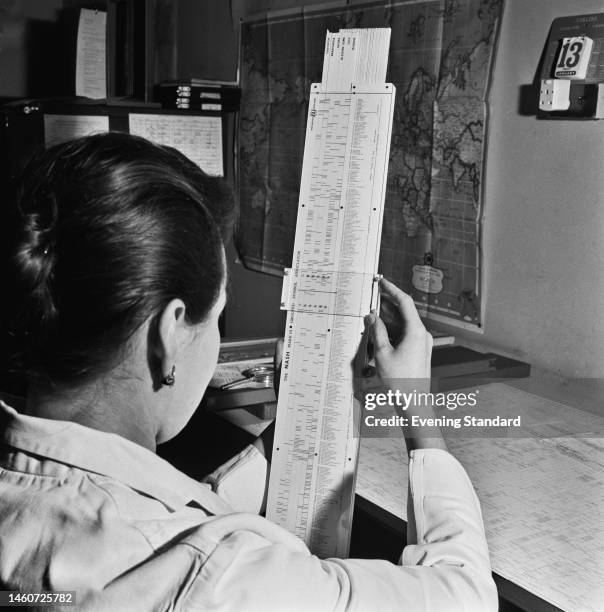 Woman named as Elizabeth Rolls holding a Nash Logoscope, a diagnostic slide-rule designed by Dr Firmin Nash for use by GPs, on January 30th, 1961.