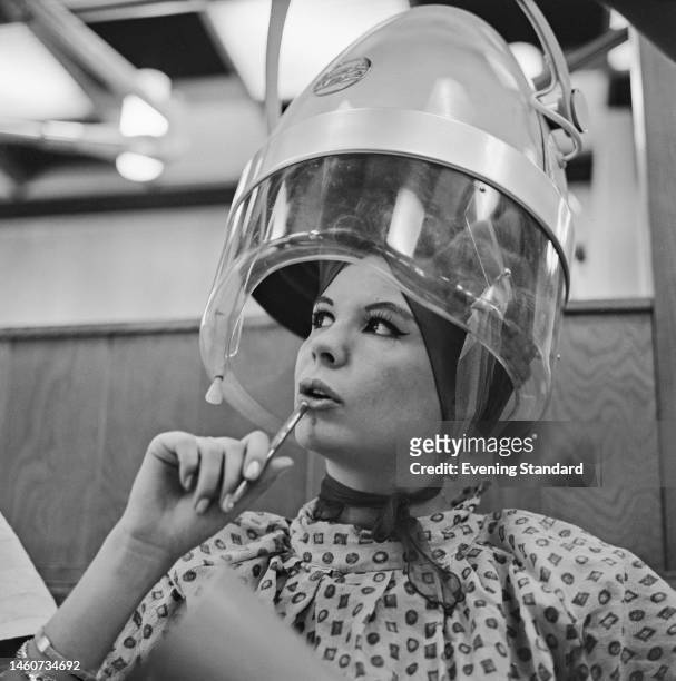 Contestant sitting under a hair dryer backstage at the Lyceum Ballroom in London where the Miss World 1962 beauty pageant is being held, on November...