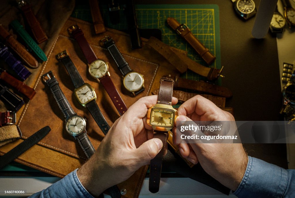 Watch collector is adjusting the mechanical watch in his workshop