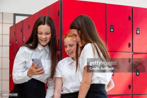 scrolling through social media with friends at school - female high school student stock pictures, royalty-free photos & images