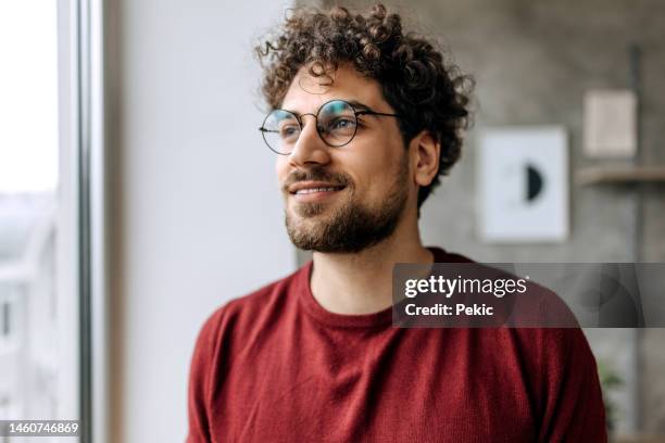 portrait of young handsome man looking through window - män i 30 årsåldern bildbanksfoton och bilder