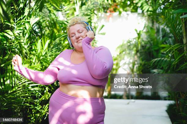 plus size model dancing with headphones - fat woman dancing stockfoto's en -beelden