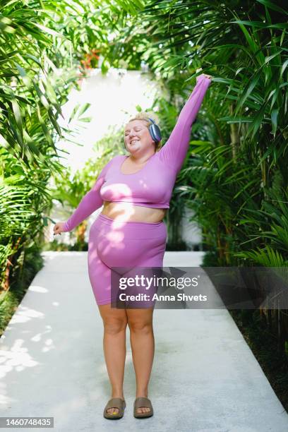 plus size model dancing with headphones - fat woman dancing stockfoto's en -beelden