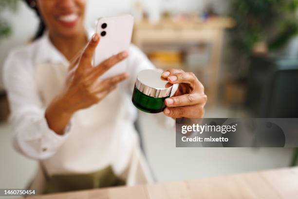 close up shot of woman taking photo of jar with homemade organic skin moisturizer - touching skin stock pictures, royalty-free photos & images
