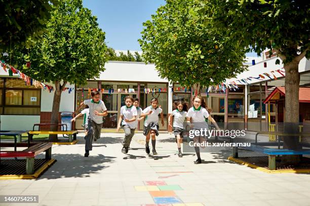 escolares haciendo ejercicio durante las vacaciones recreativas - patio de colegio fotografías e imágenes de stock