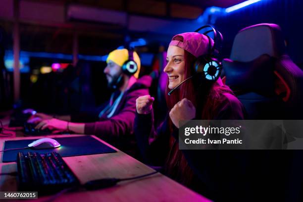 happy female gamer celebrating her victory in a video game. - gaming station stock pictures, royalty-free photos & images