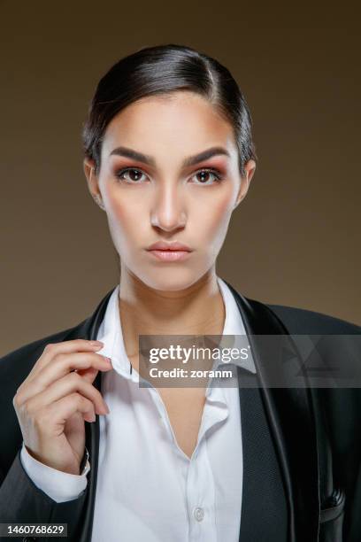 portrait of beautiful young brunette with hair back, wearing black jacket and looking at camera - lapel 個照片及圖片檔