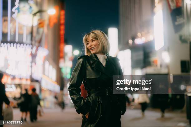 woman enjoying tokyo at night in winter - weißer mantel stock-fotos und bilder