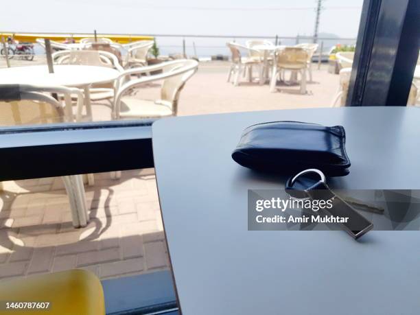 closeup of car key and wallet lying on table. - car keys table stock-fotos und bilder