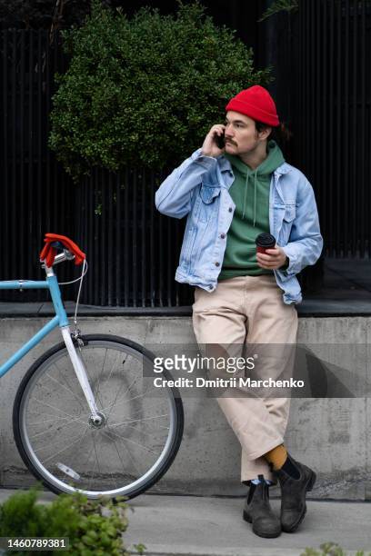 successful sociable man cyclist takes break from bike ride to drink coffee or answer phone call - georgian man stock pictures, royalty-free photos & images