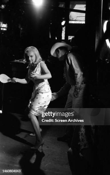 Marilyn Monroe plays table tennis in a scene with Montgomery Clift during filming the John Huston movie 'The Misfits', 1961.