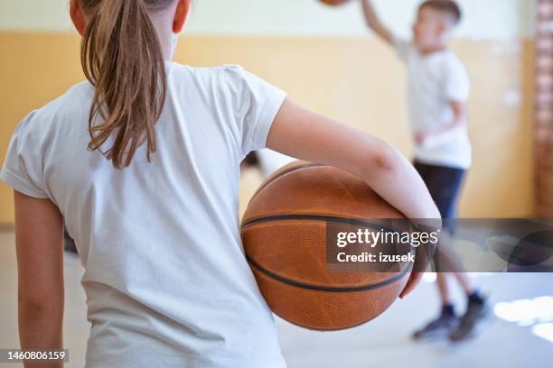 back view of school girl holding basketball ball - back stock pictures, royalty-free photos & images