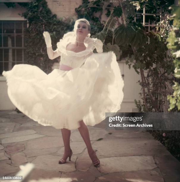 American actress Vera-Ellen posing in white dress as she twirls, circa 1950.