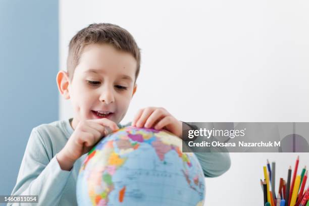 caucasian boy holds globe white background - physical geography fotografías e imágenes de stock