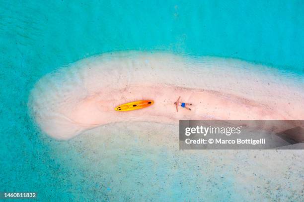 man relaxing on a sandbar with kayak, aerial view, philippines - dramatische landschaft stock-fotos und bilder