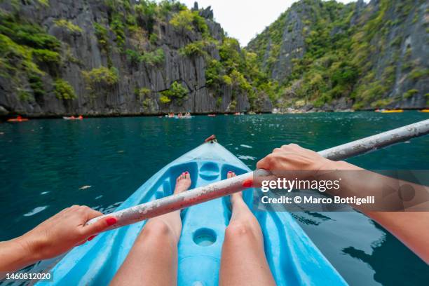 personal perspective of woman kayaking at twin lagoon, palawan, philippines - filmperspektive stock-fotos und bilder