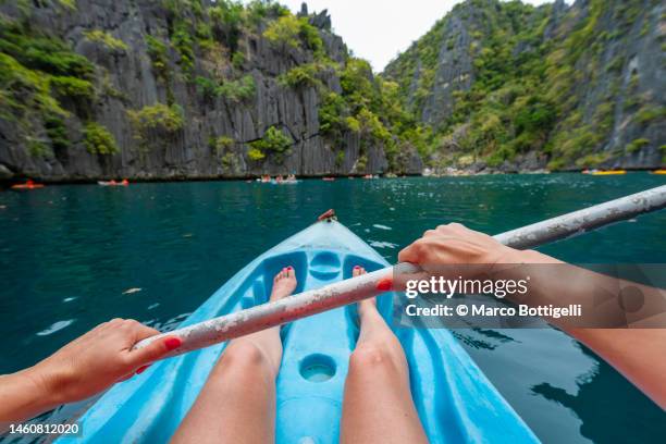 personal perspective of woman kayaking at twin lagoon, palawan, philippines - angle fotografías e imágenes de stock
