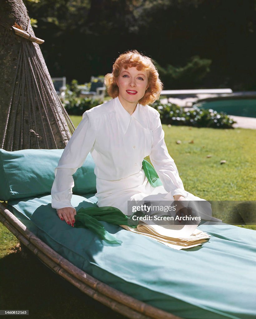 Page Garson Greer Garson in a white outfit, posing on a hammock at her Hollywood ...