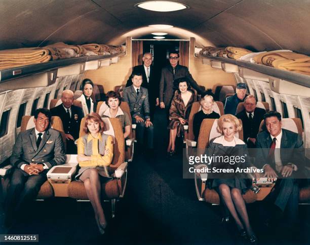 The director, producer and principle cast members on an aircraft set during filming of 'Airport', 1970. Front row, left to right: Dean Martin,...