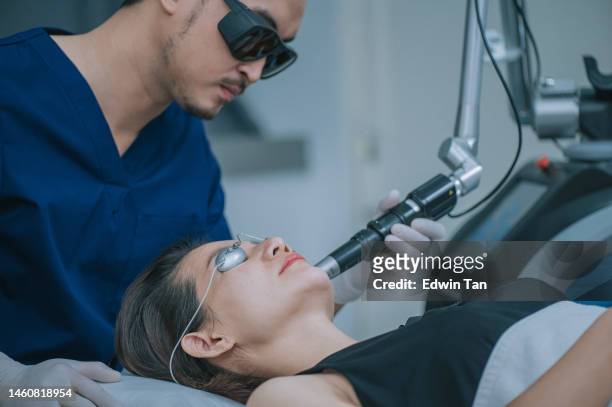 asian chinese male aesthetician laser ipl treatment on his female patient in clinic - beauty laser stock pictures, royalty-free photos & images