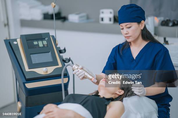 asian chinese female aesthetician giving microdermabrasion treatment to her patient - tighten stock pictures, royalty-free photos & images