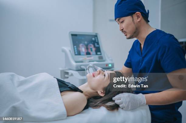 asian chinese male aesthetician using ultrasound smas face lifting on patient face - southeast asian ethnicity stock pictures, royalty-free photos & images