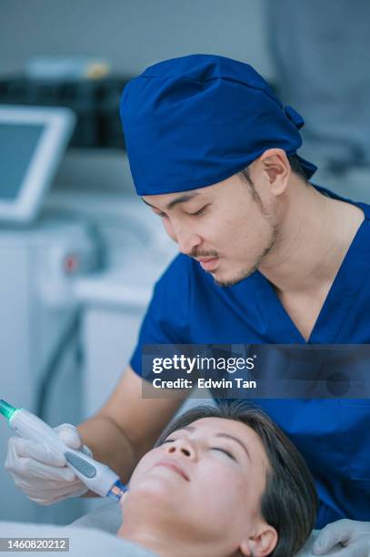 asiatische chinesische männliche kosmetikerin mikrodermabrasion behandlung für weibliche klientin in der klinik - male hair removal stock-fotos und bilder