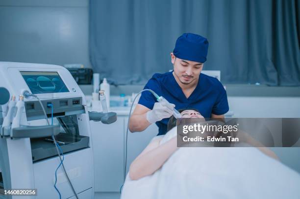 asian chinese male aesthetician microdermabrasion treatment for female client in clinic - hyperpigmentation stock pictures, royalty-free photos & images