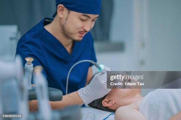 asian chinese male aesthetician microdermabrasion treatment for female client in clinic - hyperpigmentation stock pictures, royalty-free photos & images