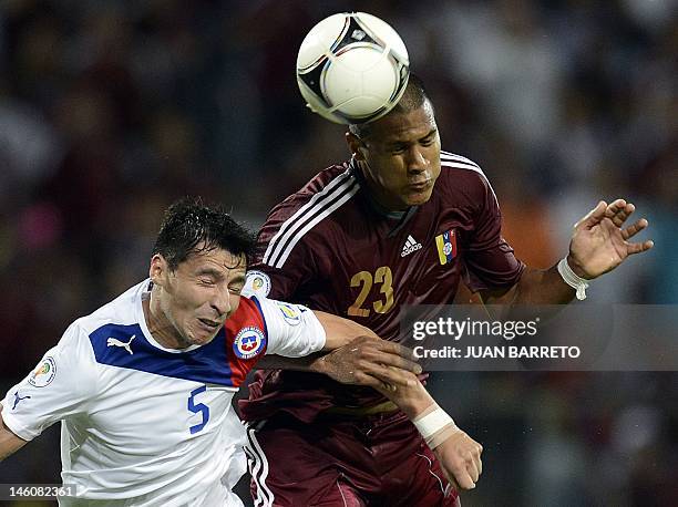 Venezuelan Salomon Rondon heads the ball next to Chilean Pablo Contreras during their Brazil 2014 FIFA World Cup South American qualifier match held...