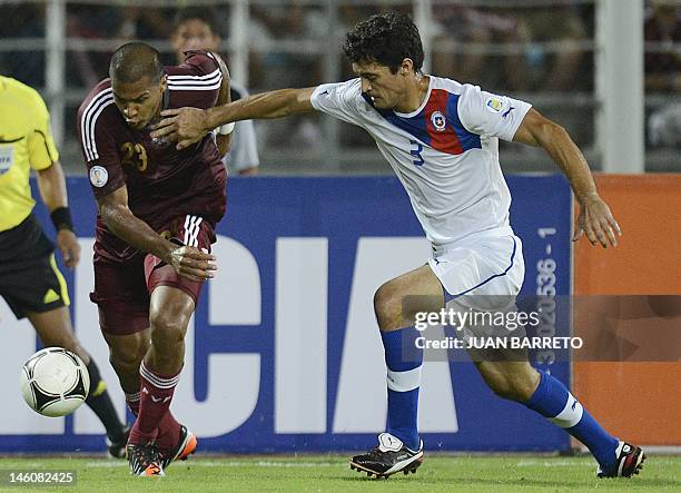 Venezuelan Salomon Rondon tries to get away from Chilean Marcos Gonzalez during their Brazil 2014 FIFA World Cup South American qualifier match held...
