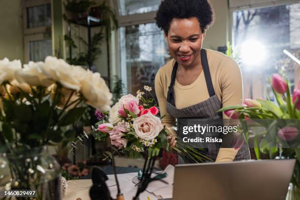 flower shop owner is arranging flower bouquets - floral arranging stock pictures, royalty-free photos & images