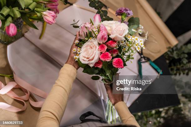 donna che organizza il bouquet di fiori in un negozio di fiori - arranging flowers foto e immagini stock