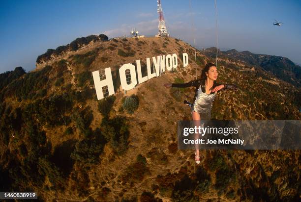 Actress Michelle Yeoh in mid-air over the famous Hollywood sign in November 1998 in Los Angeles, California